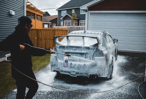 Professional mobile car pressure washing and exterior detailing service in action